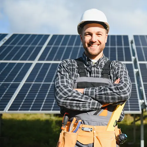 a smiling technician standing in front of solar panels